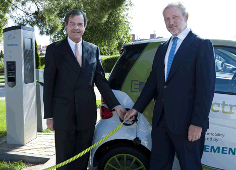 A la izquierda, Francisco Belil, CEO de Siemenes España. A su lado, José Luis López-Schümmer, presidemnte de Mercedes-Benz España, junto a los smart electric drive adquiridos por Siemens y los puntos de recarga en la sede de la compañía en Tres Cantos.