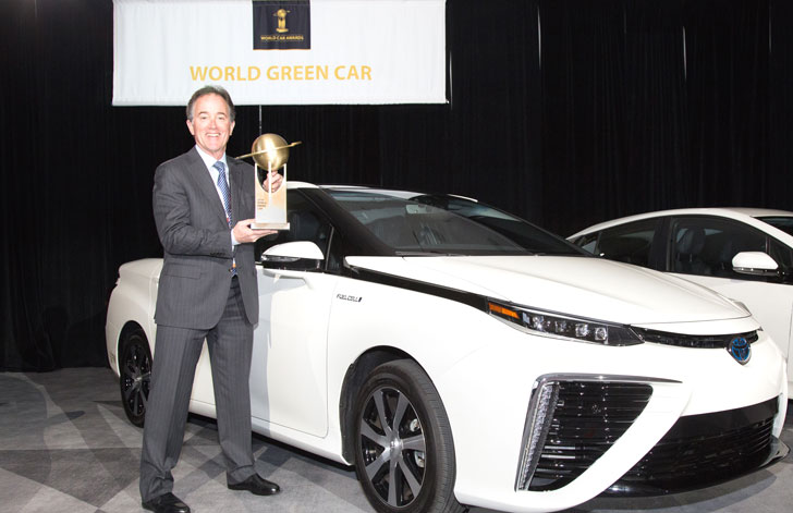Karl Schlicht, directivo de Toyota, recoge el galardón y posa junto al vehículo premiado