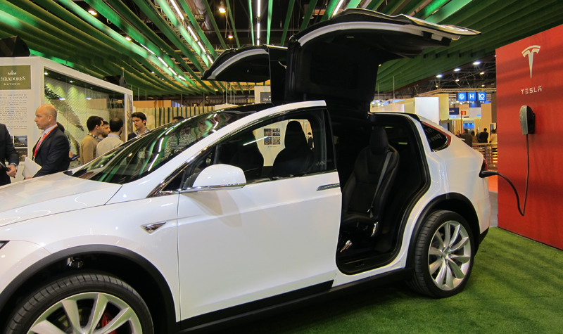 Modelo de vehículo eléctrico y conectado respetuoso con la movilidad sostenible enchufado a la electricidad y en carga.