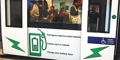 Indicadores que informan a los viajeros de cargadores para dispositivos móviles en el vagón de la Línea 2 de Metro de Barcelona.