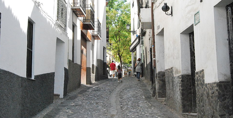 Calle con pendiente dentro del barrio del Albaicín, el más emblemático de la ciudad por su arquitectura e historia. 