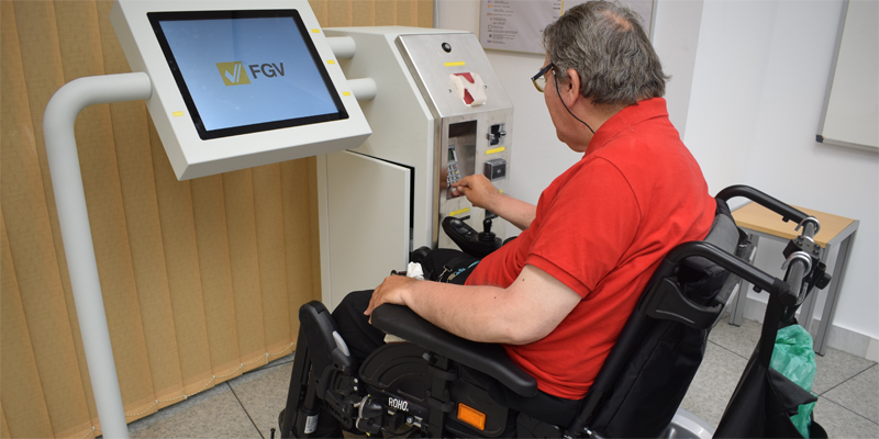 Un hombre en silla de ruedas prueba el prototipo de máquina de venta de billetes accesible de Ferrocarriles de la Generalitat Valenciana.