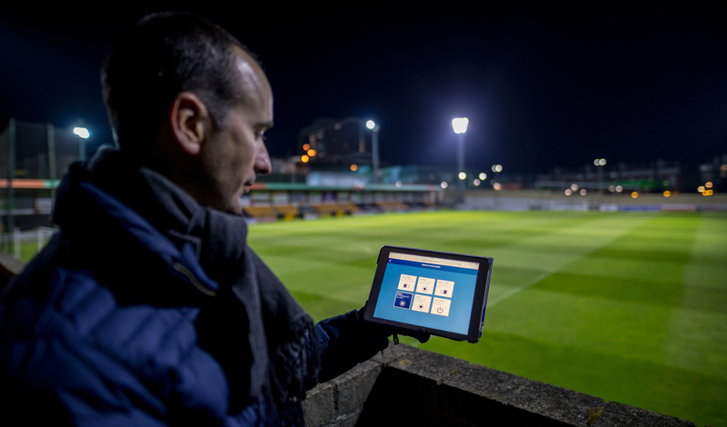 Técnico de Signify controla la iluminación del estadio con una tablet que enseña en primer término