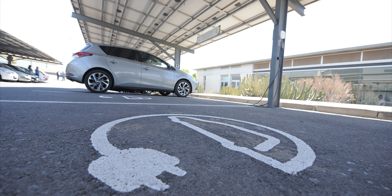 Símbolo pintado sobre el asfalto que indica que hay un punto de recarga para vehículos eléctricos en un aparcamiento.
