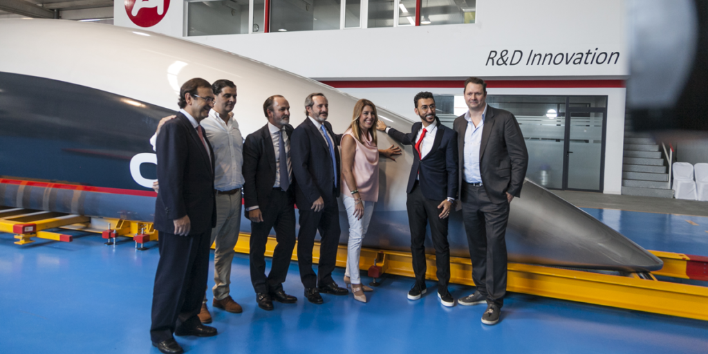 Las autoridades de Andalucía y los responsables de las empresas implicadas posan delante de la cápsula de pasajeros de Hyperloop.