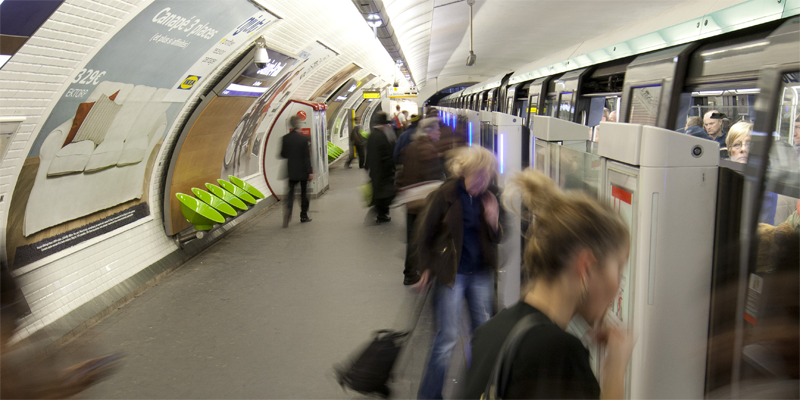 Andén del metro de París con un metro parado y los pasajeros subiéndose.