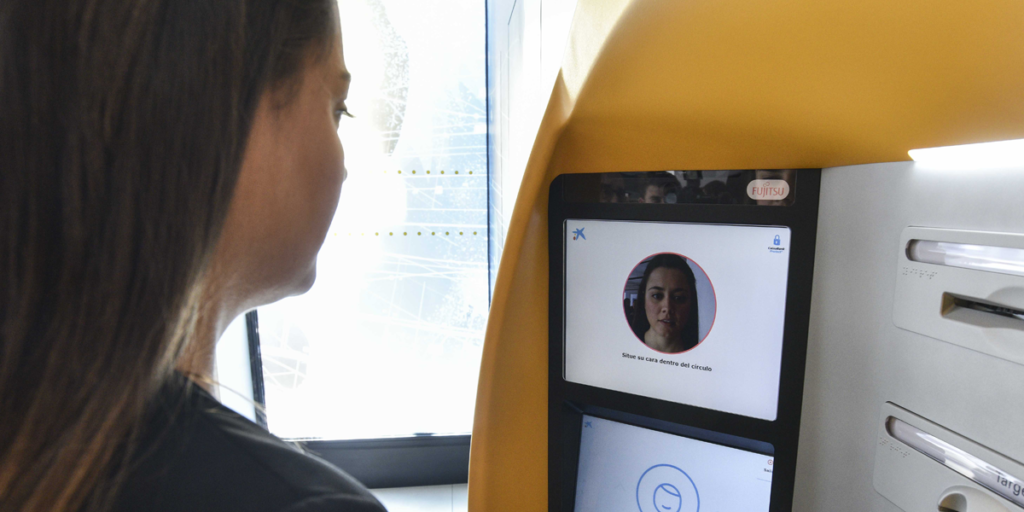 Una clienta de CaixaBank prueba uno de los cajeros automáticos en los que está disponible la tecnología de reconocimiento facial para identificarse a la hora de sacar dinero.