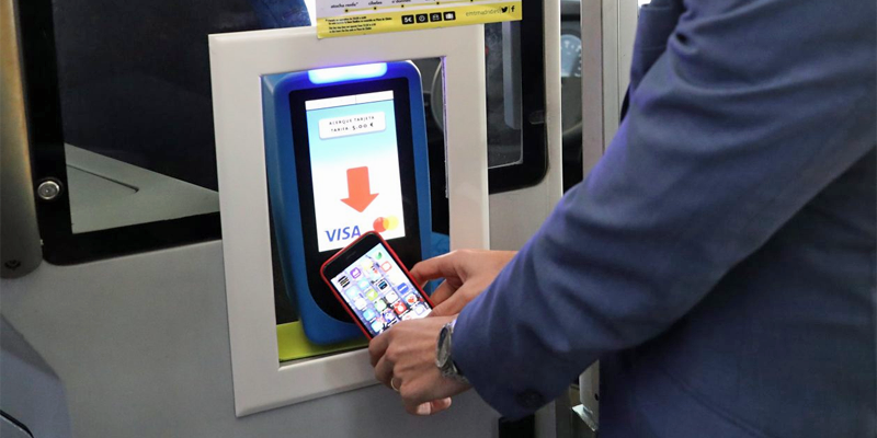 Un usuario paga su billete sencillo de autobús mediante el nuevo sistema contactless con su teléfono móvil.