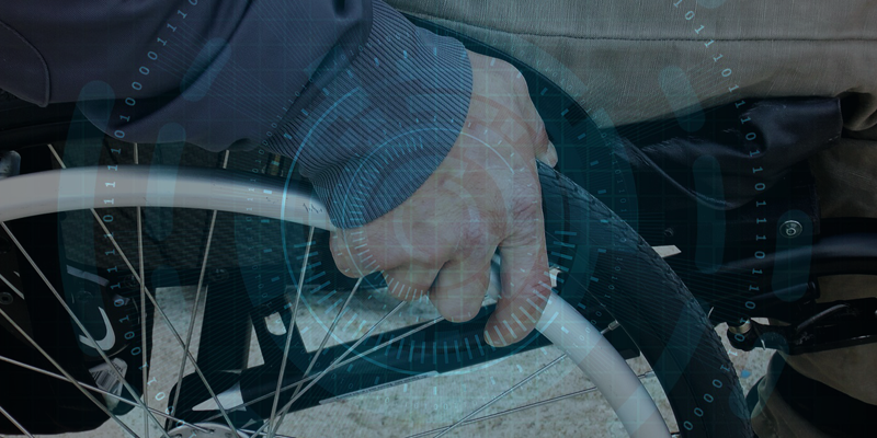 Una mano en la rueda de una silla de ruedas y un fondo de ceros y unos representando las tecnologías digitales.