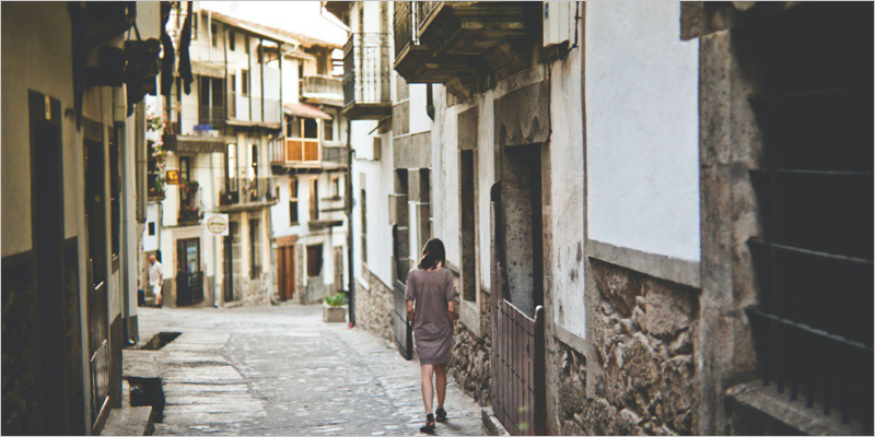 mujer anda en la calle de un pueblo
